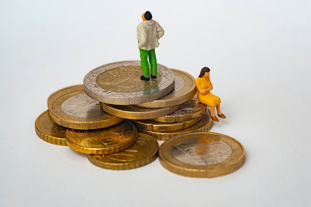 Stack of coins with small figurines of a man and woman representing alimony Maryland laws