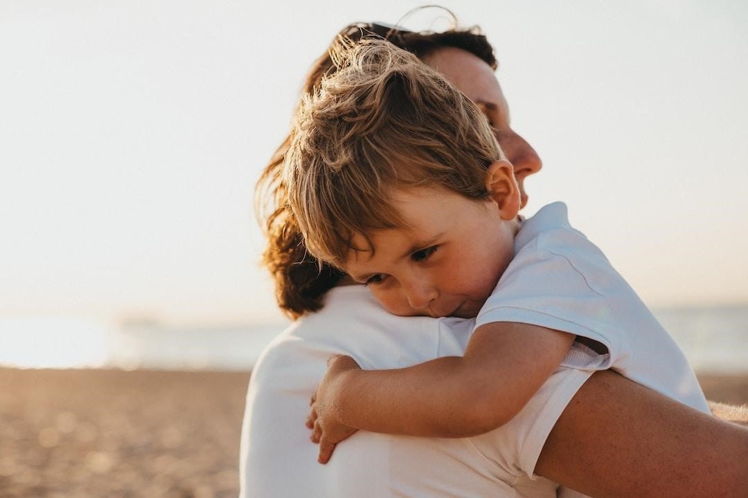 A son hugging his father as a parent with sole legal custody