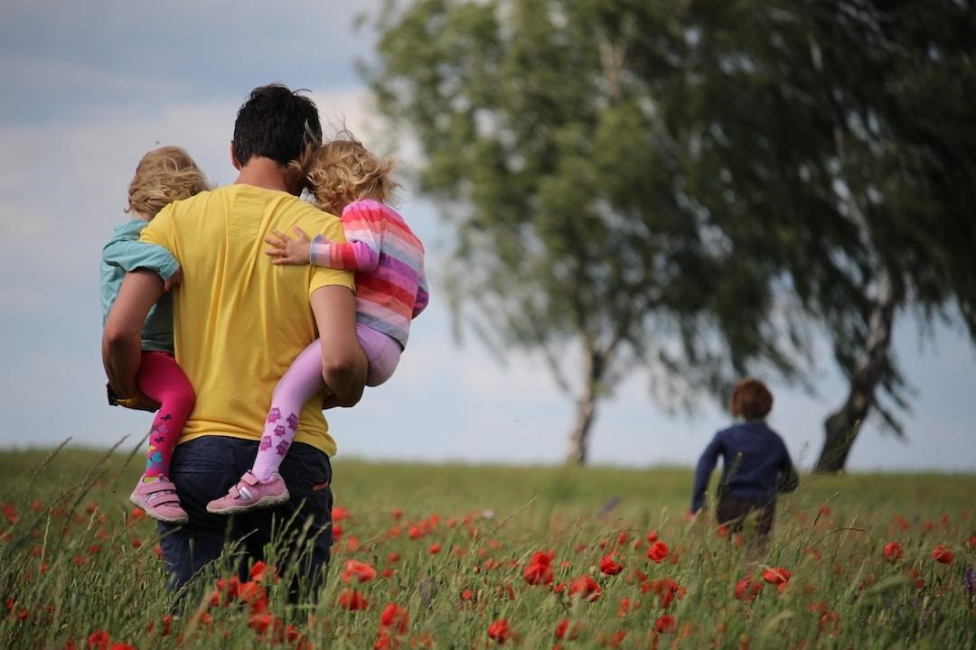 Father spending time with his three children in a flower field