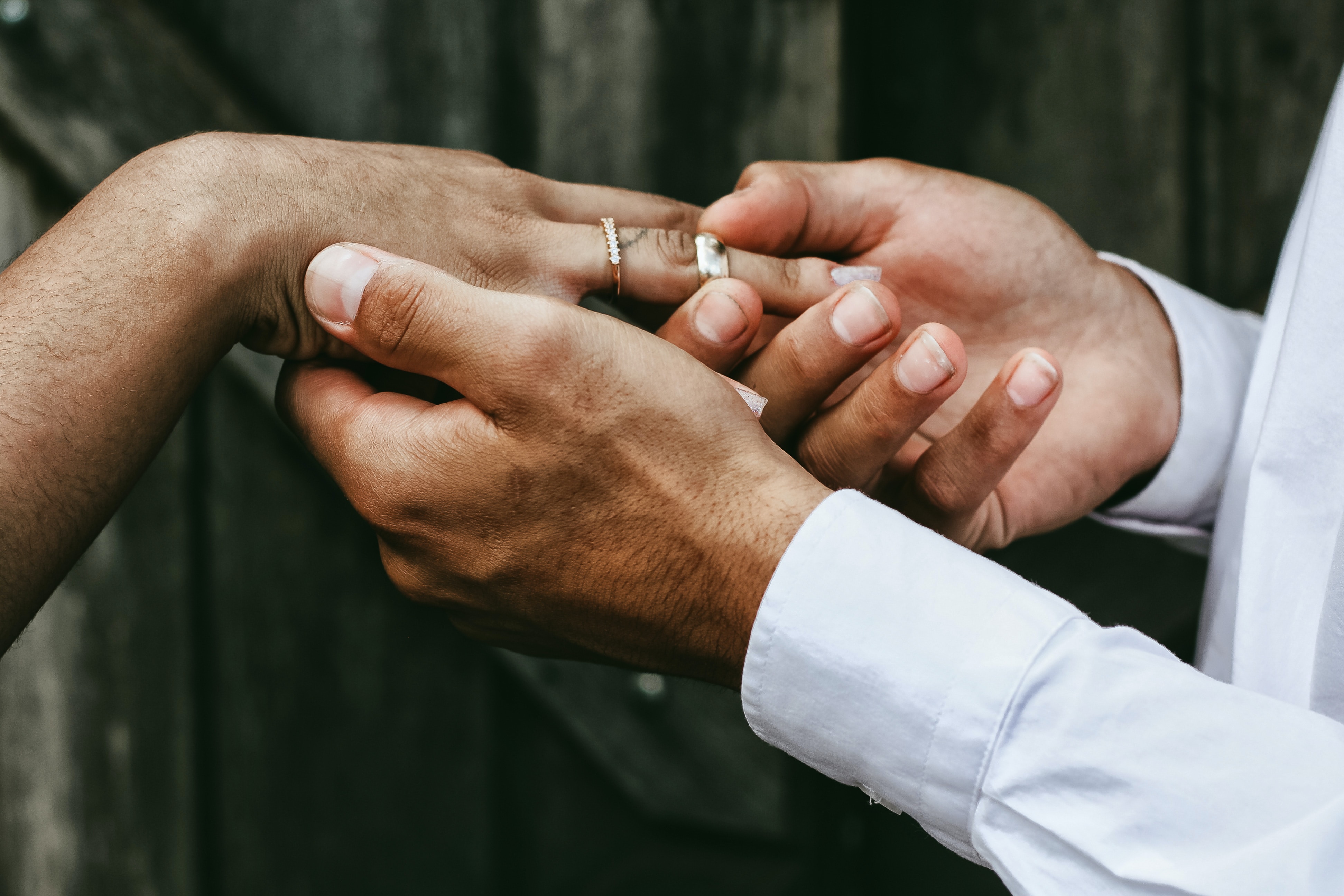 A couple holding hands and showing their rings after getting married.